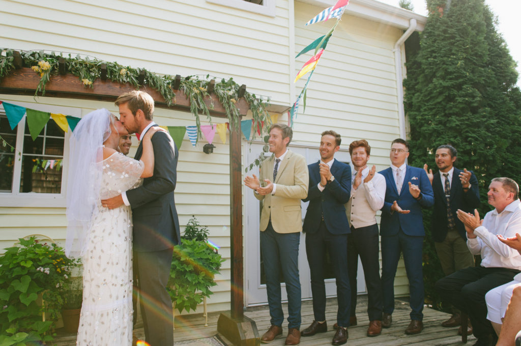 colourful backyard abbotsford wedding ceremony kiss